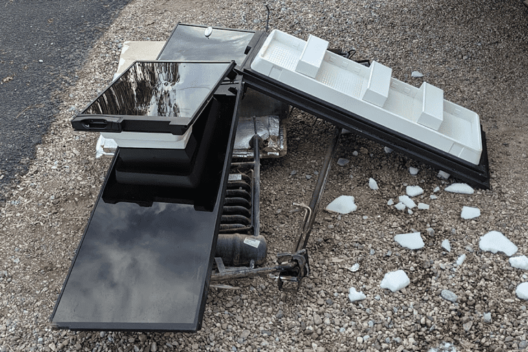 norcold rv refrigerator on the ground in pieces