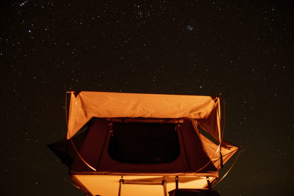 tent illuminated under starry night sky