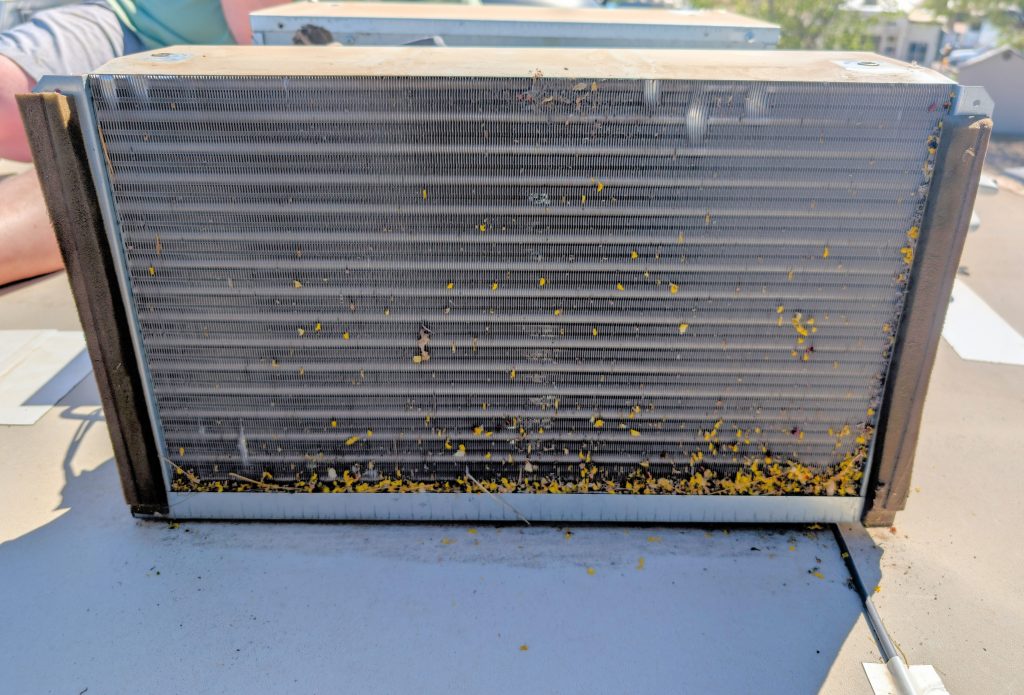 How To Clean Rv Air Conditioner Coils (Without Losing Your Mind Or Your Balance) 2 an rv air conditioner coil full of tree debris