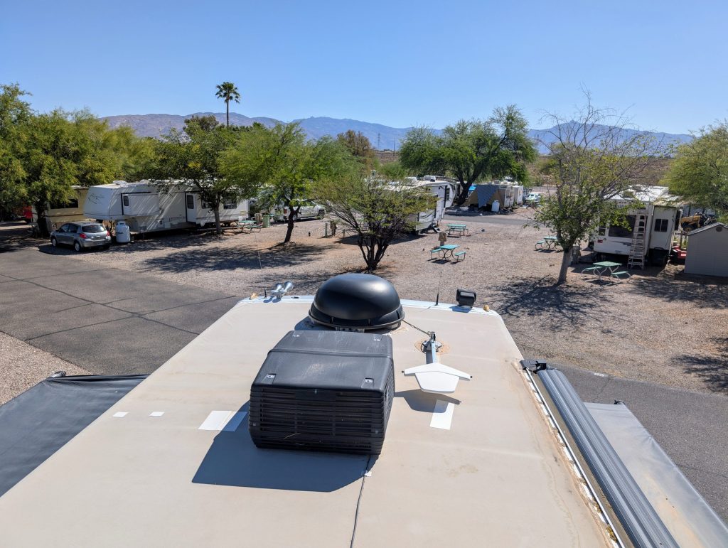 How To Clean Rv Air Conditioner Coils (Without Losing Your Mind Or Your Balance) 3 view from the roof of a class a diesel pusher in an rv park with mountains in the background