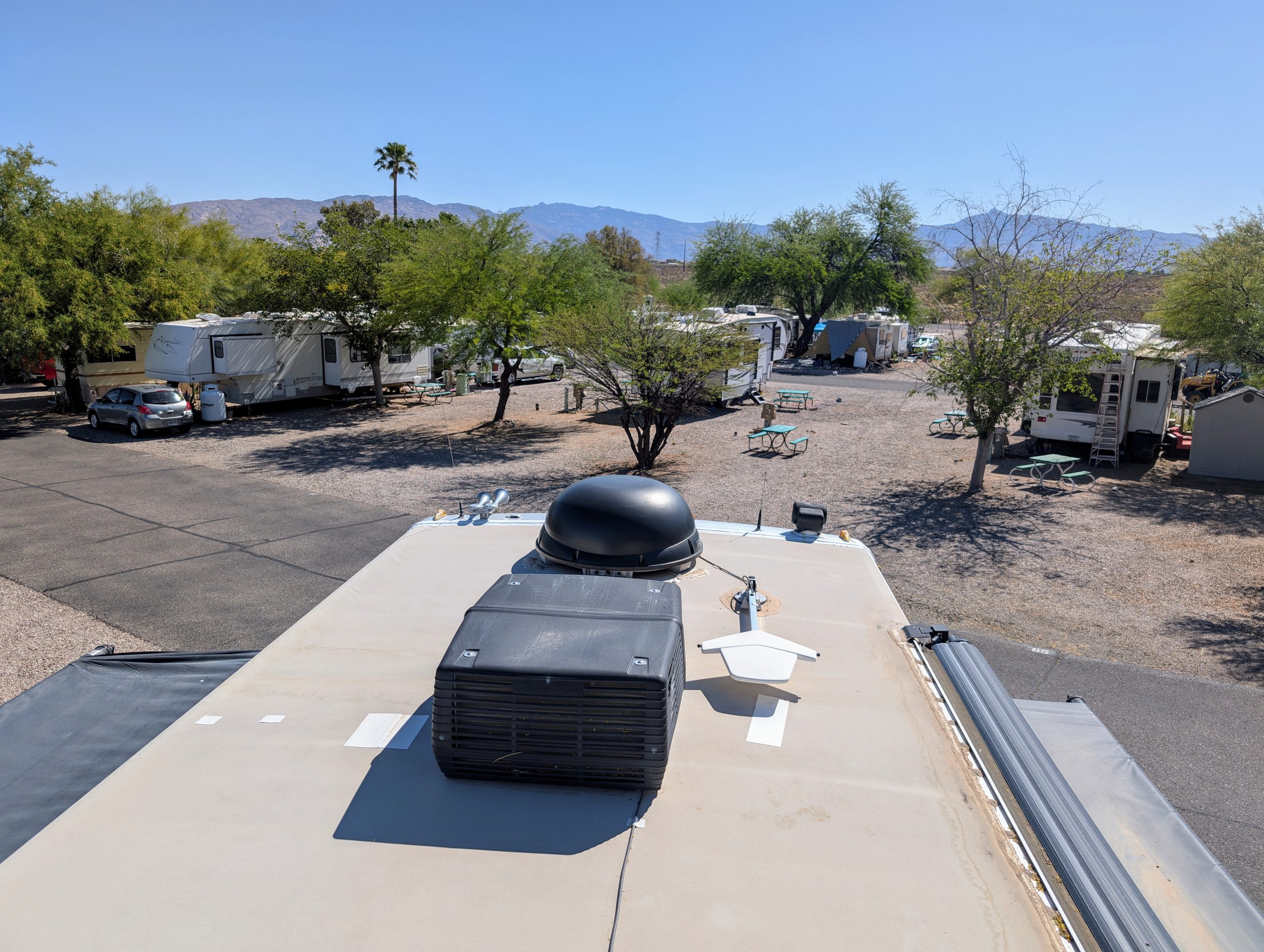 view from the roof of a class a diesel pusher in an rv park with mountains in the background